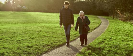 Two people walking through a park