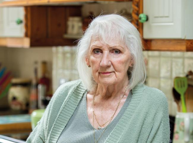 Headshot of woman with kitchen in background